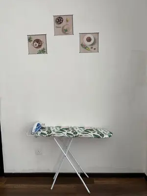 a table against a white wall with pictures on it at Nova Highlands Hilltop Retreat Cameron Highlands in Brinchang