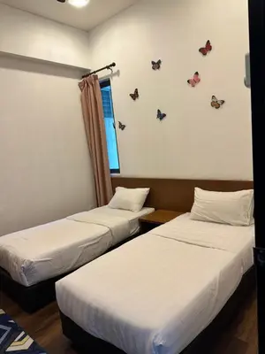 two beds in a room with butterflies on the wall at Nova Highlands Hilltop Retreat Cameron Highlands in Brinchang