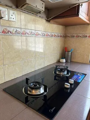 a kitchen with two burners on top of a stove at Double Storey Terrace House in Perai