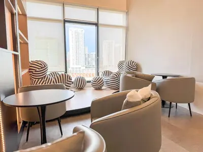 a waiting room with chairs and tables and large windows at Panoramic Georgetown City & Sea View with Netflix in Jelutong