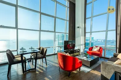 a living room with a table and chairs and large windows at Seaview Seafront Duplex in Town with WiFi & Full Kitchen 23 in George Town