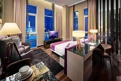 a hotel room with a king sized bed and a living room at Big BathTub Premium Seafront Studio in Town with WiFi & Full Kitchen in George Town