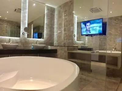 a bathroom with a tub and two sinks and a tv at Big BathTub Premium Seafront Studio in Town with WiFi & Full Kitchen in George Town