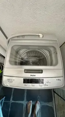 a person standing in front of a washing machine at Big BathTub Premium Seafront Studio in Town with WiFi & Full Kitchen in George Town