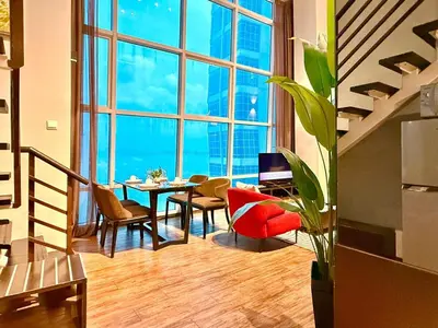 a living room with a table and chairs and a large window at Seaview Seafront Duplex in Town with WiFi & Full Kitchen 10 in George Town