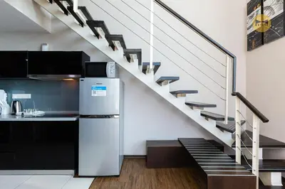 a kitchen with a refrigerator and a staircase at Seaview Seafront Duplex in Town with WiFi & Full Kitchen 10 in George Town