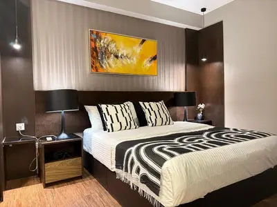 a bedroom with a large bed and a painting on the wall at Seaview Seafront Duplex in Town with WiFi & Full Kitchen 10 in George Town
