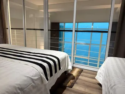 a bedroom with a bed and a view of the ocean at Seaview Seafront Duplex in Town with WiFi & Full Kitchen 16 in George Town