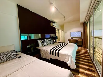 a hotel room with two beds and a television at Seaview Seafront Duplex in Town with WiFi & Full Kitchen 16 in George Town