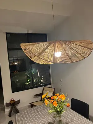 a large pendant light hanging over a table with flowers at Brickyard at 6 in Ipoh