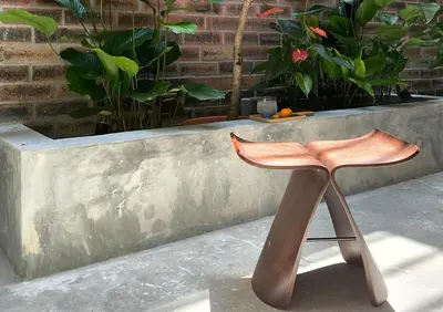a wooden chair sitting in front of a planter at Brickyard at 6 in Ipoh