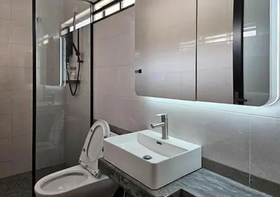 a bathroom with a sink and a toilet and a mirror at Brickyard at 6 in Ipoh