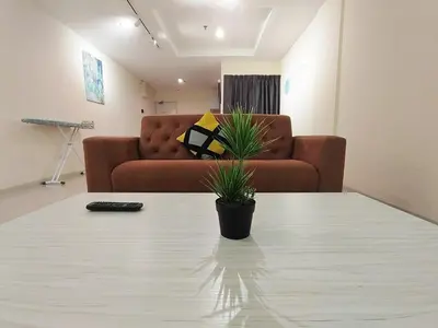 a living room with a couch and a table with a plant at D'Ocean Marina Laguna Resort by Manhattan Group in Lumut