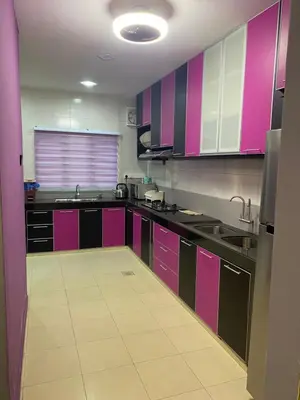 a kitchen with purple and pink cabinets and a kitchen floor at Budget Homestay Lahat in Ipoh