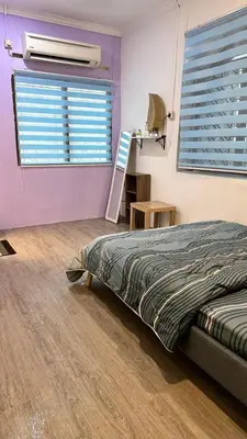 a bedroom with a bed and a window with a fan at Raintown House in Taiping