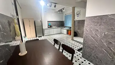 a kitchen with a table and chairs and a refrigerator at Raintown House in Taiping