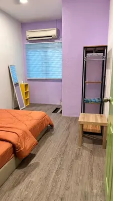a bedroom with an orange bed and a purple wall at Raintown House in Taiping