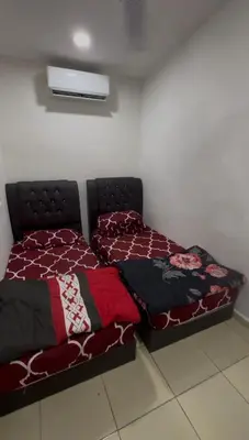 a bed in a room with a bedspread on it at Wika Homestay in Lunas