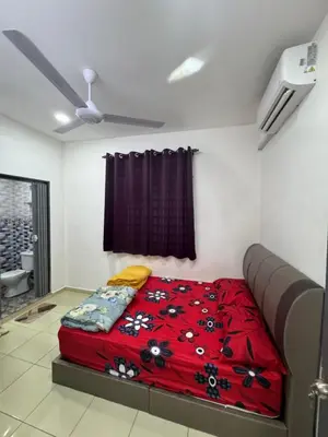 a bedroom with a bed with a red blanket at Wika Homestay in Lunas