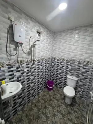 a bathroom with a toilet and a sink at Wika Homestay in Lunas