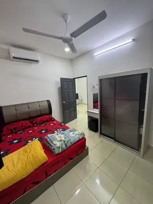 a bedroom with a bed and a flat screen tv at Wika Homestay in Lunas