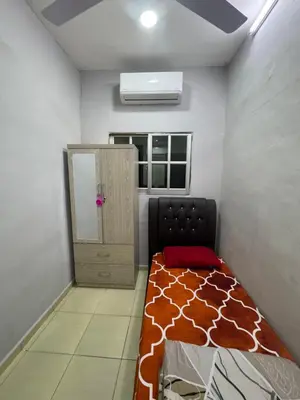 a small room with a bed and a window at Wika Homestay in Lunas