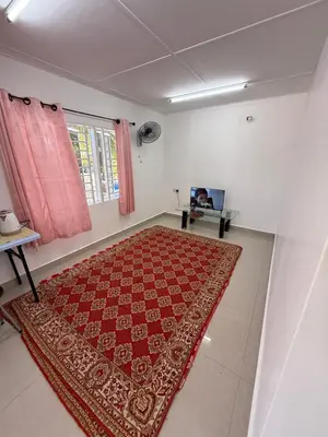 a living room with a red rug on the floor at Teratak Laman Bari in Sekincan