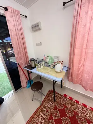 a table with pots and pans on it in a room at Teratak Laman Bari in Sekincan
