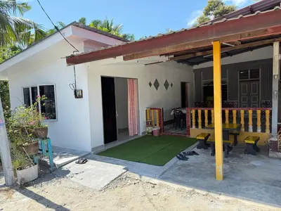 a house with a patio with a green lawn at Teratak Laman Bari in Sekincan