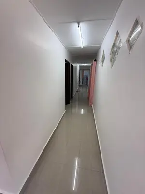 a hallway with white walls and a long hallway with white floors at Teratak Laman Bari in Sekincan