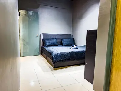 a dog sitting on a bed in a room at NDD Homestay in Sitiawan