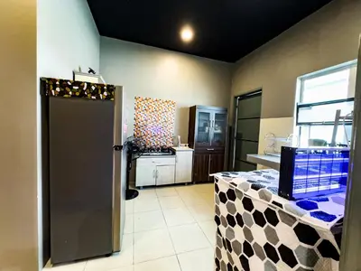 a kitchen with a door open to a kitchen with a counter at NDD Homestay in Sitiawan