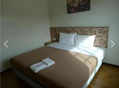 a bedroom with a bed with a book on it at Golf View Apartment in Brinchang in Tanah Rata