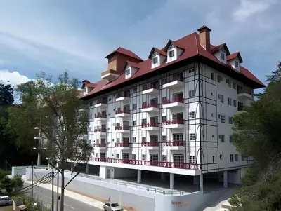 a large white building with a red roof at Golf View Apartment in Brinchang in Tanah Rata