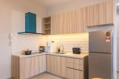 a small kitchen with a refrigerator and a sink at Iconic Regency by Stellar ALV in Bayan Lepas