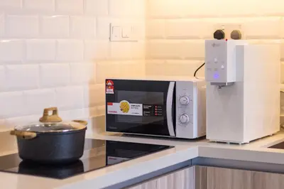 a kitchen with a microwave and a pot on a counter at Iconic Regency by Stellar ALV in Bayan Lepas