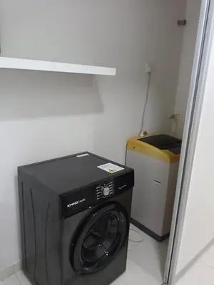 a washer and dryer in a corner of a room at Fatty House in Kampar