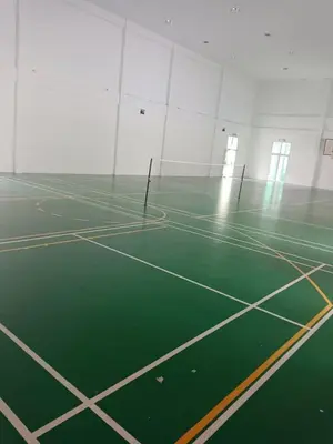an empty gymnasium with a green tennis court at Fatty House in Kampar