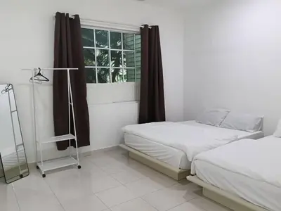 a bedroom with two beds and a window at Fatty House in Kampar