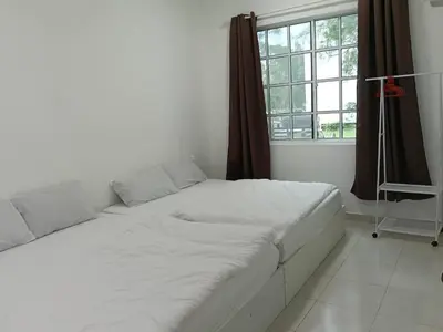 a white bed in a room with a window at Fatty House in Kampar