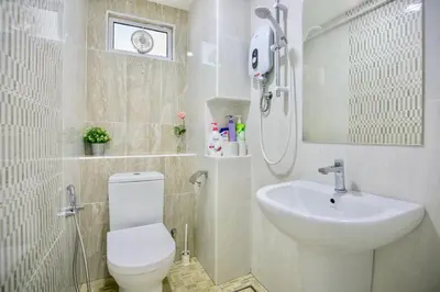 a bathroom with a white toilet and a sink at Eastern Apt, Jelutong in Jelutong
