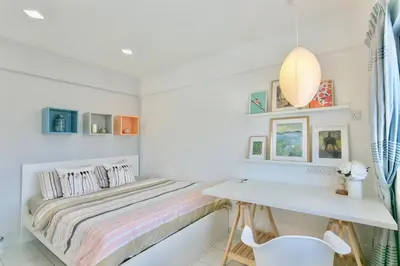 a white bedroom with a bed and a desk at Eastern Apt, Jelutong in Jelutong