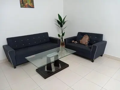 a living room with two couches and a glass table at Bayan Homestay Bayan Lepas Penang in Bayan Lepas