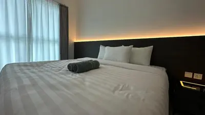 a bed in a hotel room with a pillow on it at IPOH City Centre ICC Suites by HWC in Ipoh