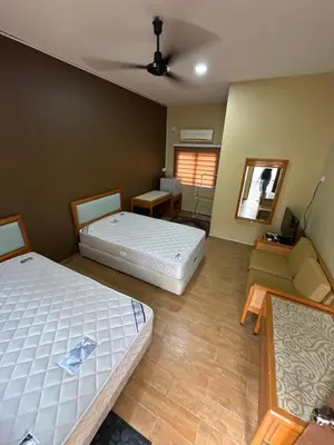 a room with two beds and a couch in it at Santai Salai Homestay and Cafe in Kepala Batas