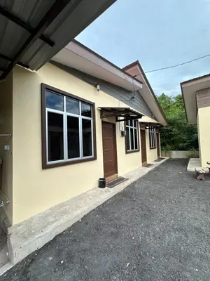 a yellow house with a driveway in front of it at Santai Salai Homestay and Cafe in Kepala Batas