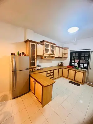 a kitchen with wooden cabinets and a stainless steel refrigerator at Rayyan'Homestay PARKVIEW in Tanah Rata