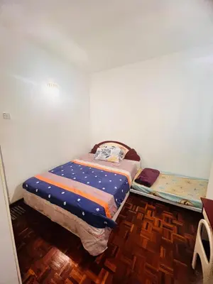 a small bed in a room with a wooden floor at Rayyan'Homestay PARKVIEW in Tanah Rata