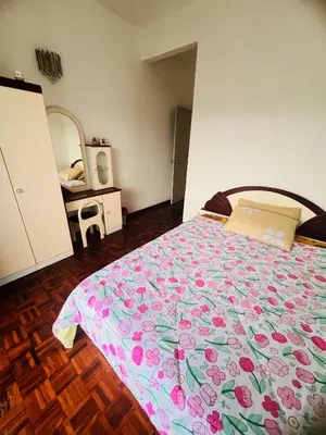 a bedroom with a bed with a floral bedspread at Rayyan'Homestay PARKVIEW in Tanah Rata