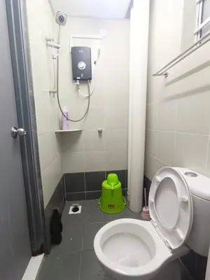 a bathroom with a toilet and a green stool at IRDINA HomestayMuslim's 2 at Emerald Avenue Brinchang Centrum in Brinchang